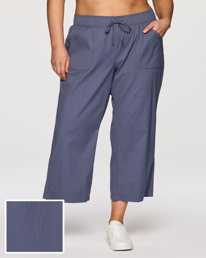 Front of a model wearing a size 1X Plus Birdie Everyday Ankle Pant in Smoke Blue by RBX Active. | dia_product_style_image_id:352927